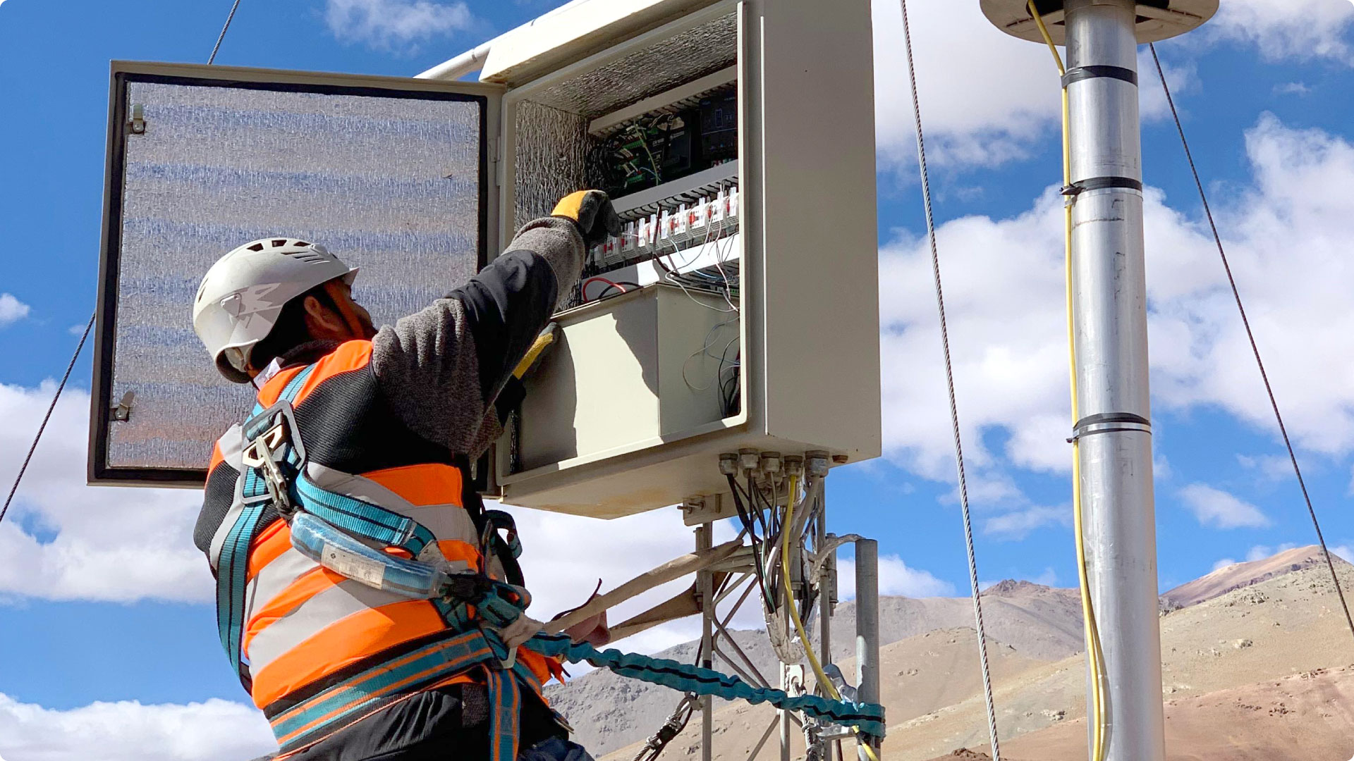 Técnico de GHM trabajando en una estación de equipos en la cordillera