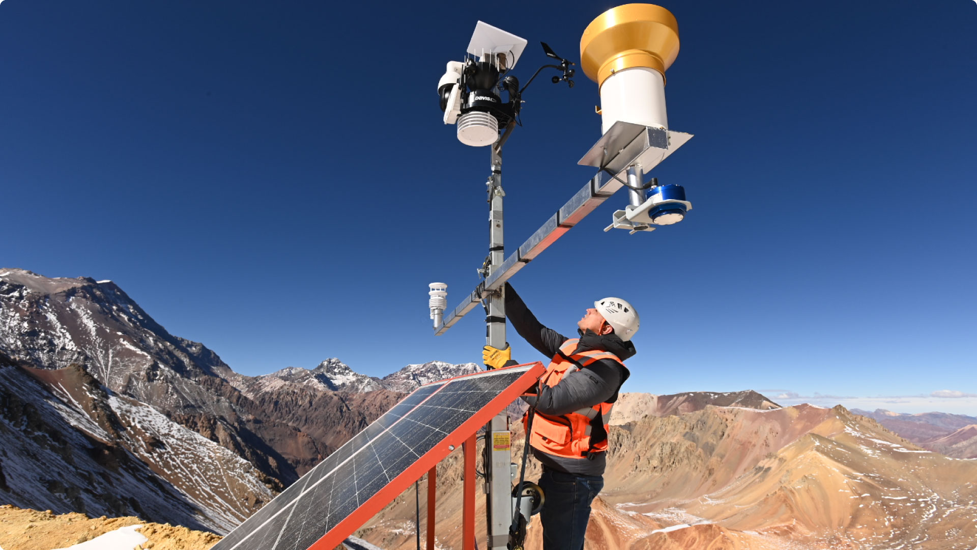 Técnico de GHM instalando una estación meteorológica en alta montaña